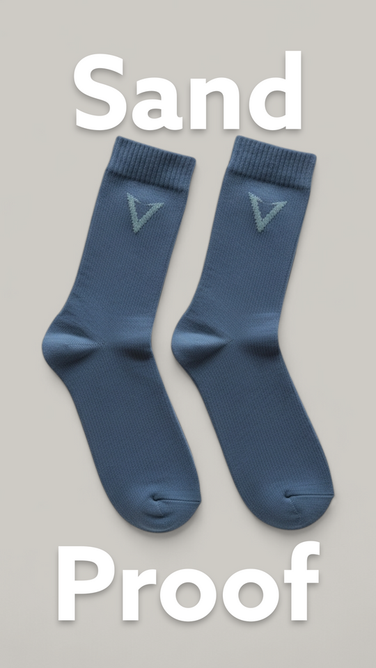 Pair of blue socks with a logo on a beige background, labeled 'Sand Proof'.